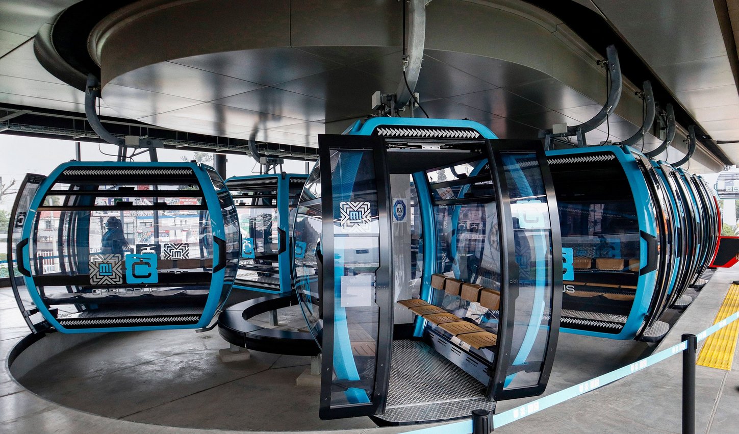 Photo of the entry and exit point of the cable bus. You can see several gondolas in a row, which are empty and whose doors are open.